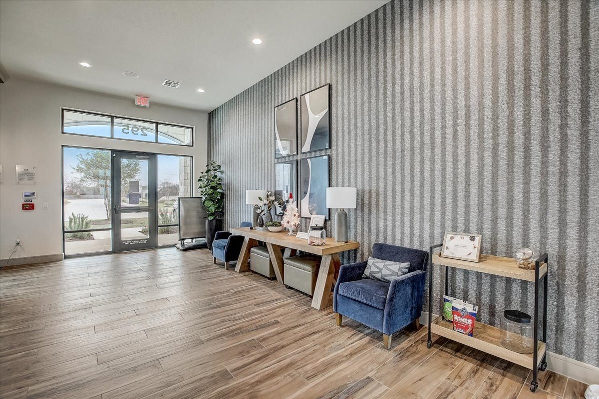 Welcoming lobby with patterned accent wall, decorative console tables, and casual seating near the entrance.